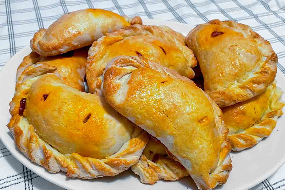 A pile of Chilean meat empanadas on a white plate