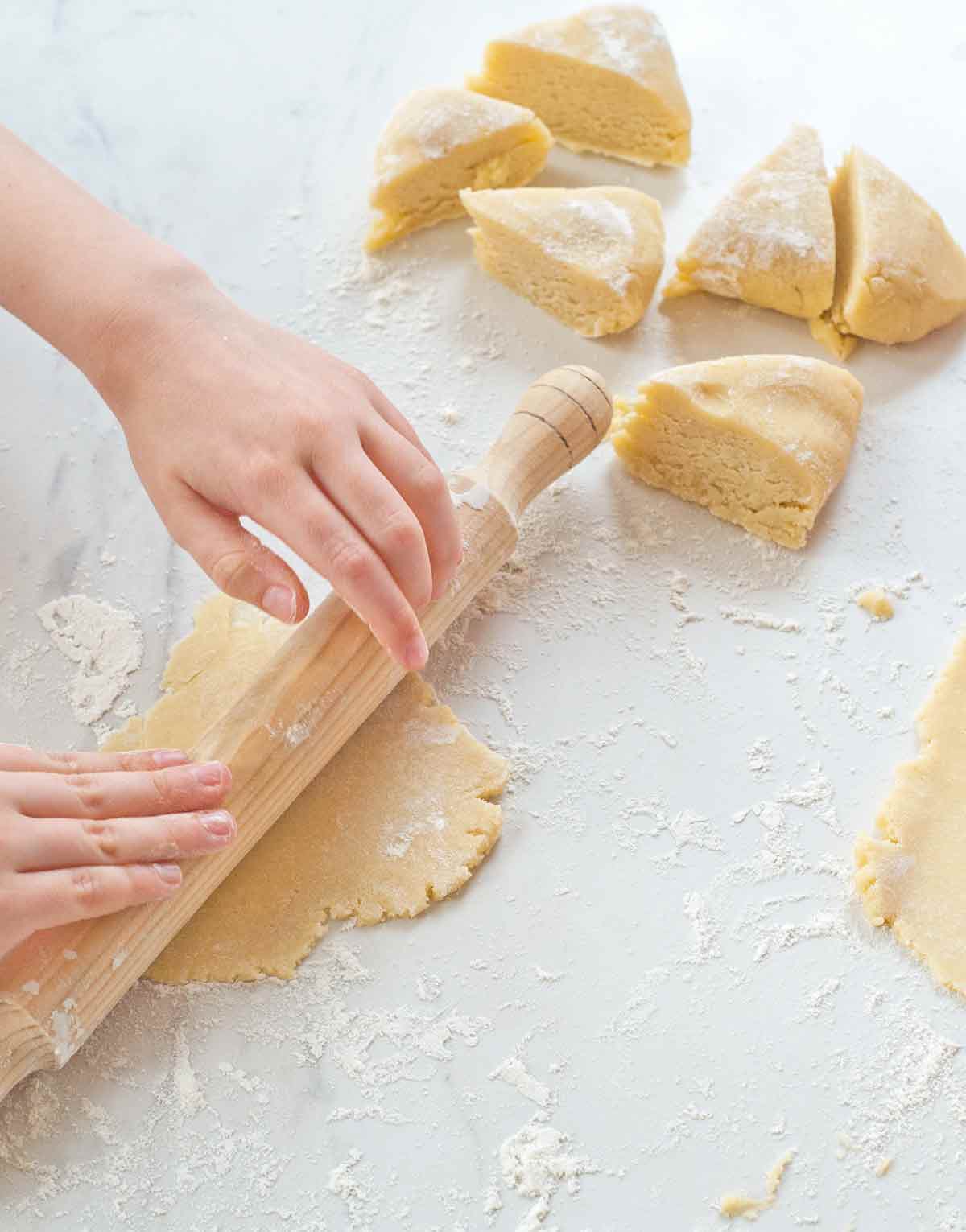 A girl's hand rolling dough