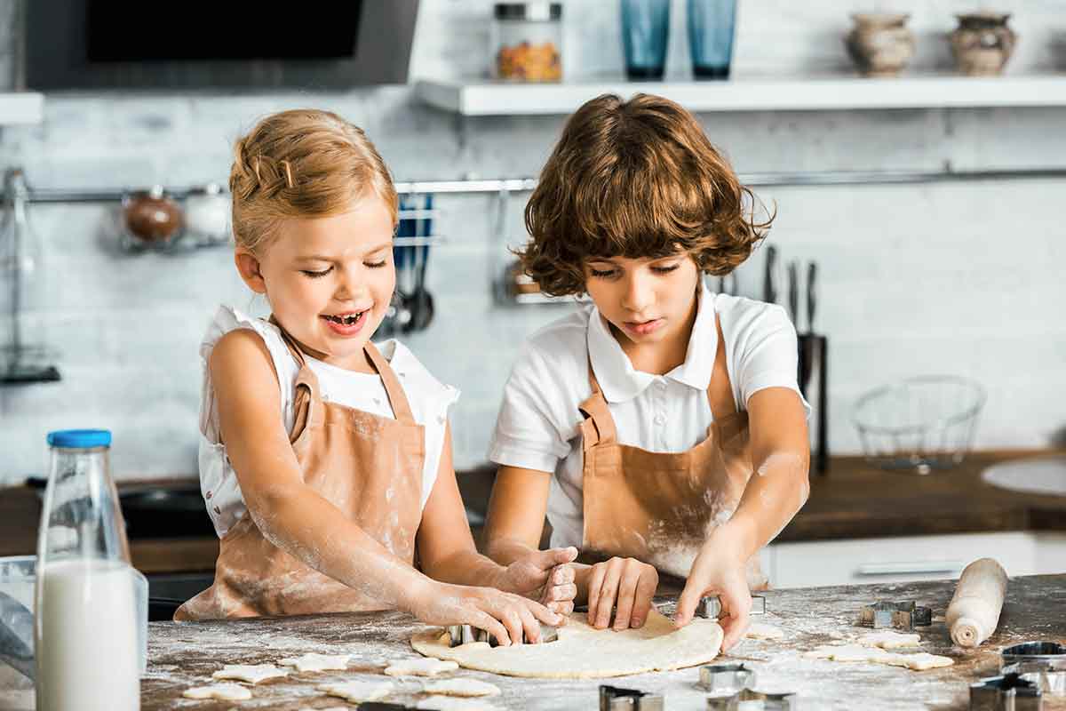 Two kids cooking and baking on a kitchen
