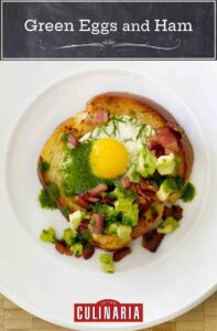 A slice of bread with a cooked egg in the center topped with ham, avocado salsa, and jalapeño oil, for a playful take on green eggs and ham.