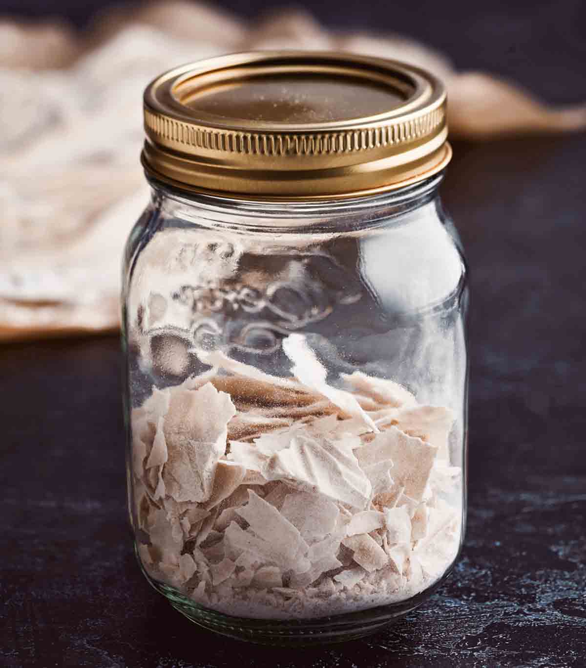 A jar of flaked dehydrated sourdough starter