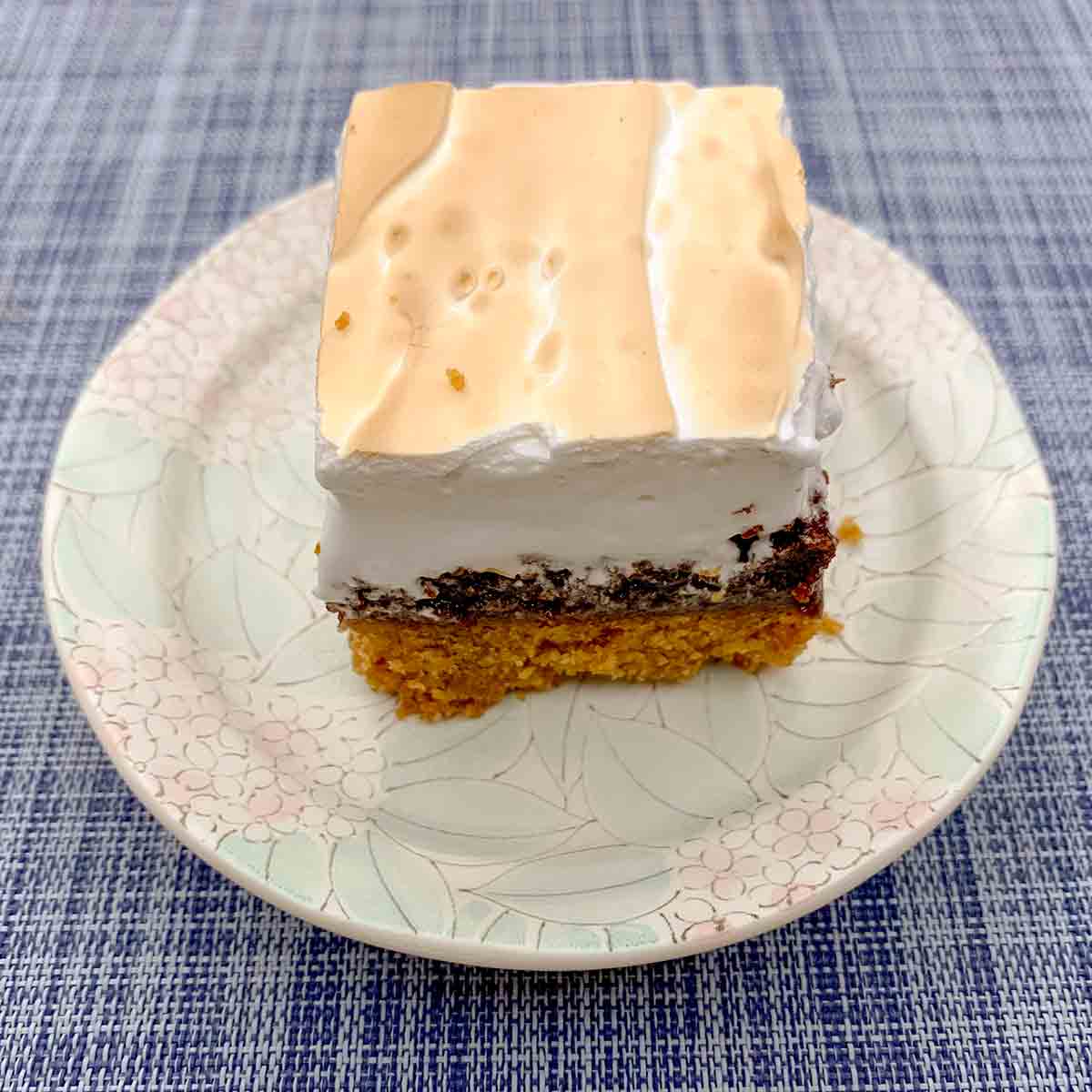 A piece of Cheryl Day's s'mores bars ona patterned plate on a blue and white placemat