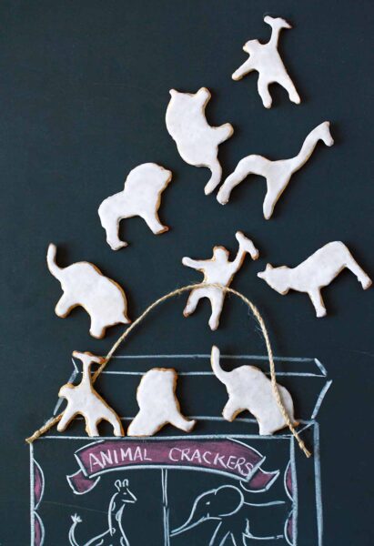 Different shapes of homemade animal crackers lying on a chalkboard background.