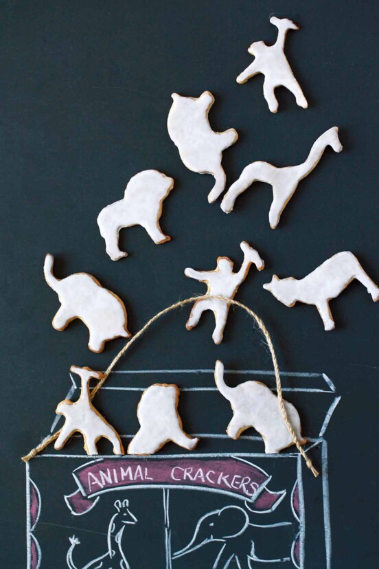 Different shapes of homemade animal crackers lying on a chalkboard background.