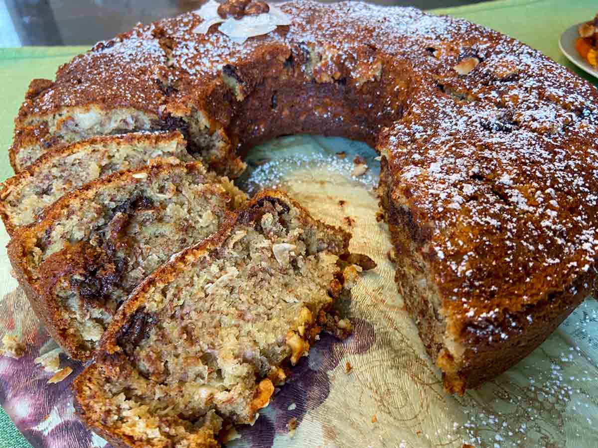 A Bundt cake of banana bread with several slices cut from it.