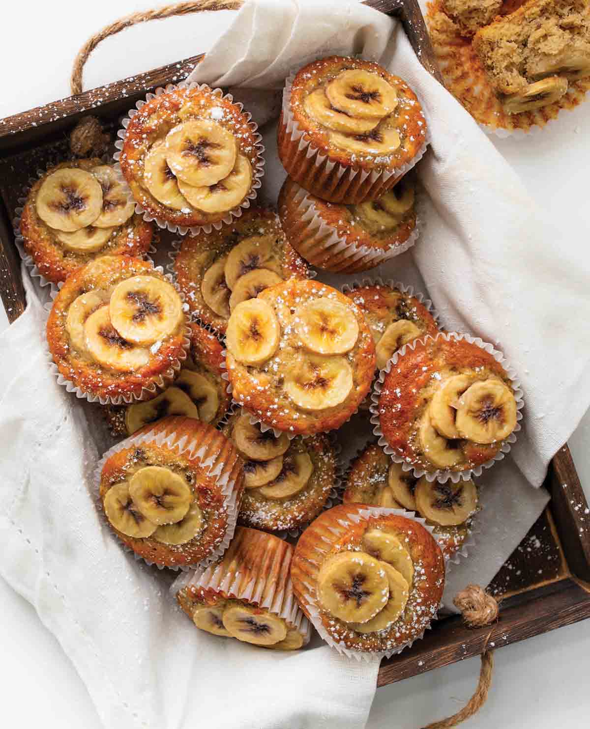 En trälåda fylld med banantoppade muffins.