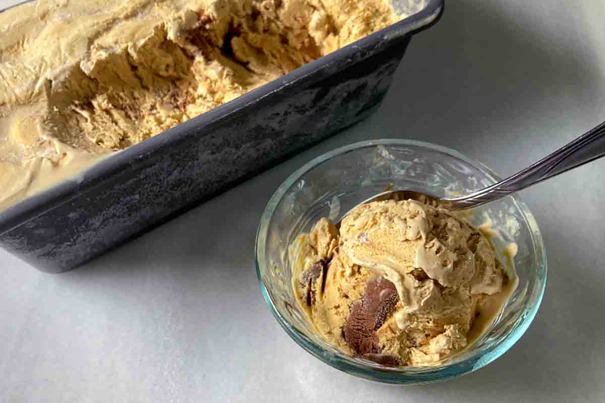 A bowl of no-churn coffee ice cream next to a loaf pan filled with it.