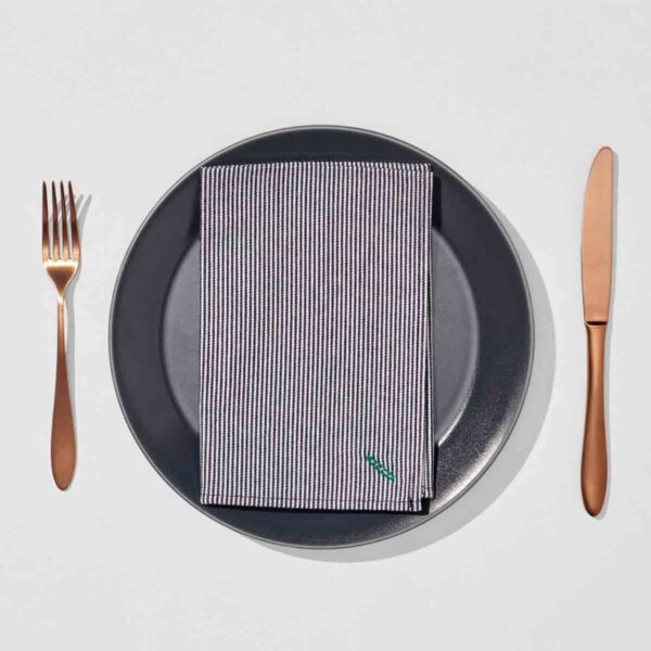 Rigby Home Flatware Set with striped napkin on black plate.