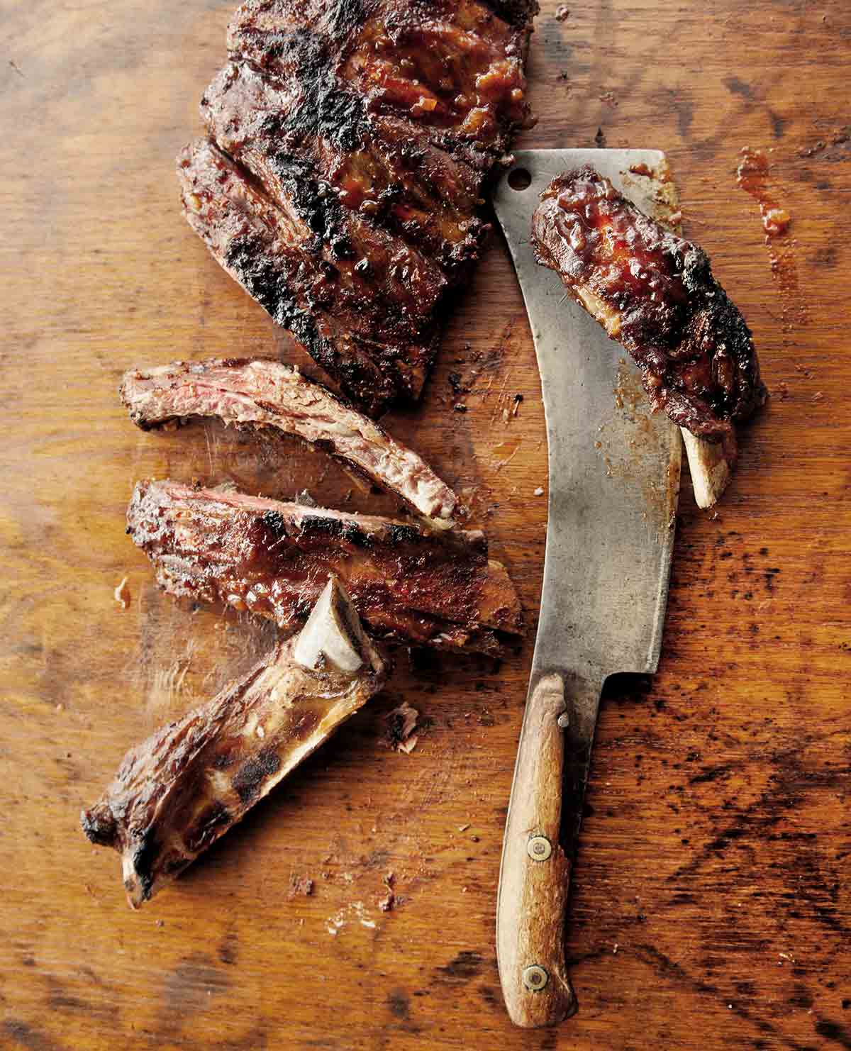 A rack of barbecue beef ribs, with four sliced off the end.