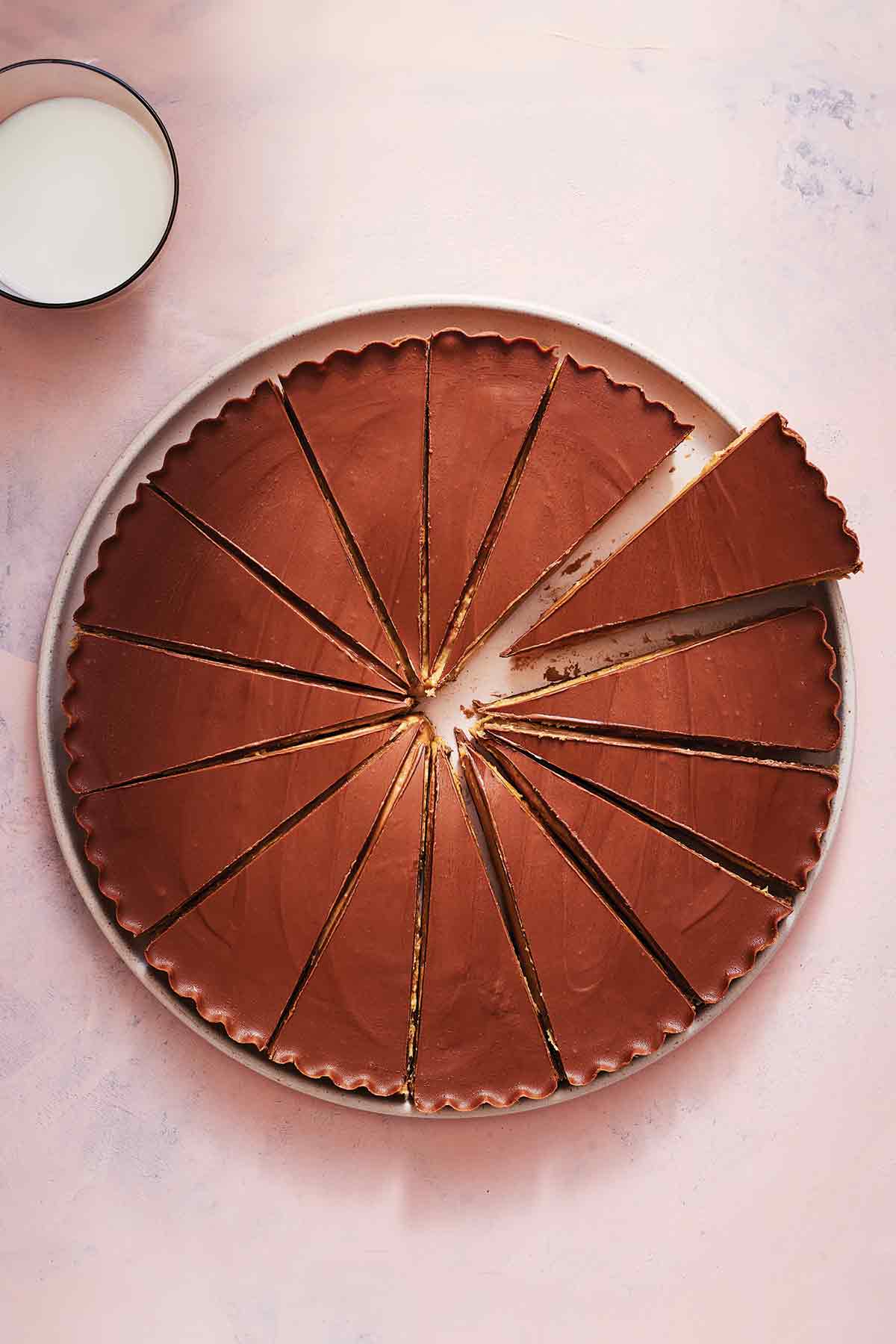 A giant peanut butter cup on a plate, cut into 15 wedges.