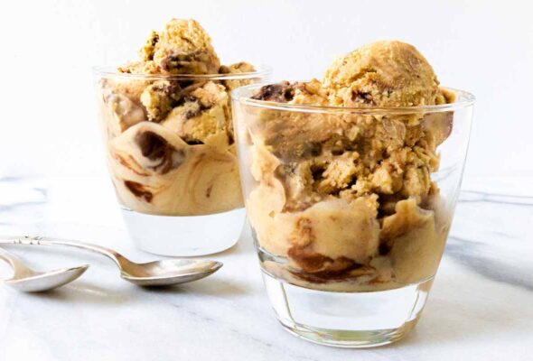 Two glasses filled with peanut butter ice cream with Nutella fudge swirled through and two spoons on the side.