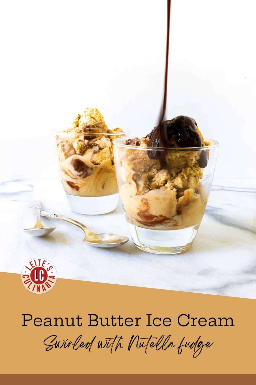 Nutella fudge pouring over a glass of swirled peanut butter ice cream, two silver spoons resting alongside.