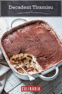 A square baking dish filled with traditional Italian tiramisu with a spoon resting inside and a portion missing.