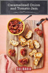 A wooden cutting board with a bowl of caramelized onion and tomato jam and several toasted baguette slices on it.