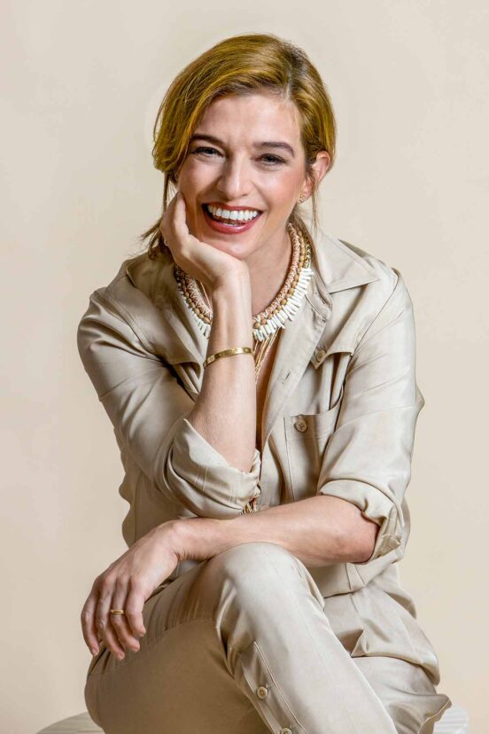 A woman, Pati Jinich, with her hand on her chin, smiling.