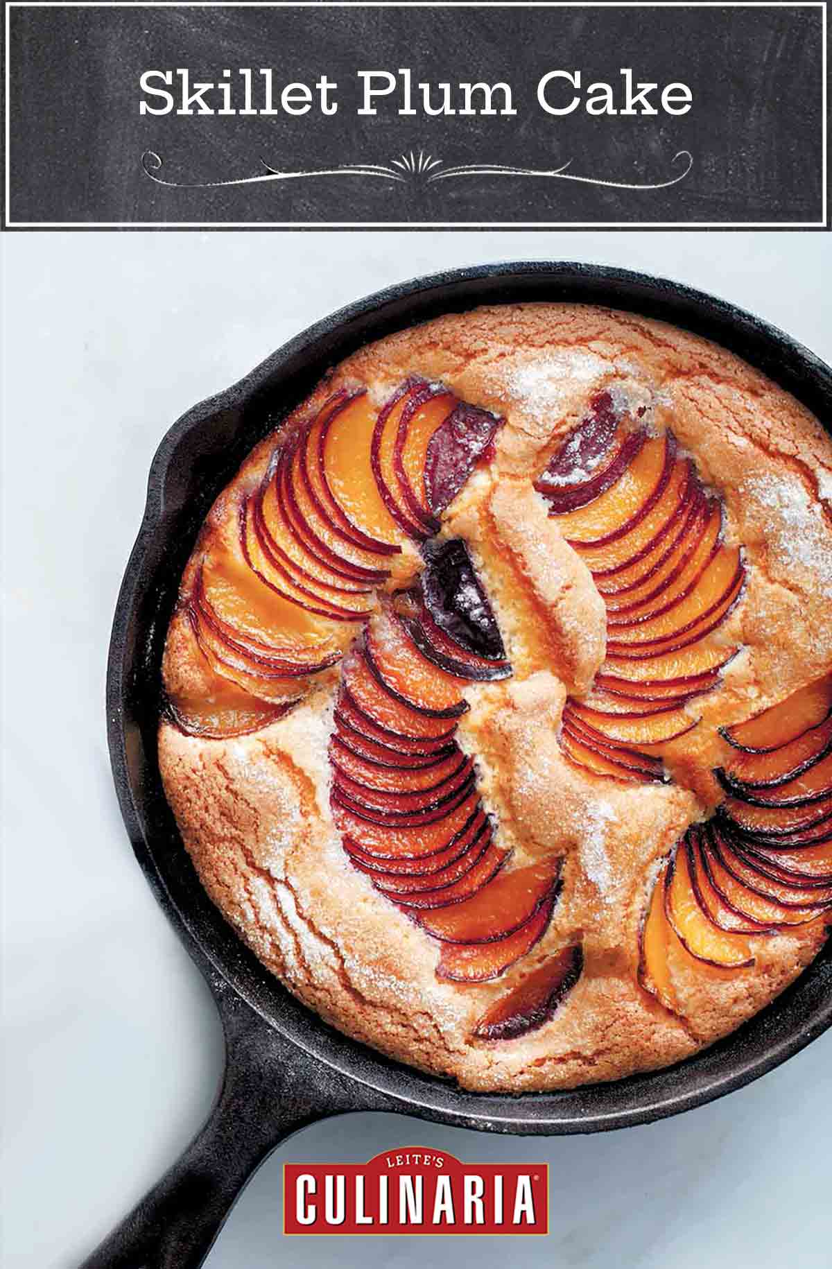 A cast-iron skillet plum cake with slices of fanned out plums baked in.