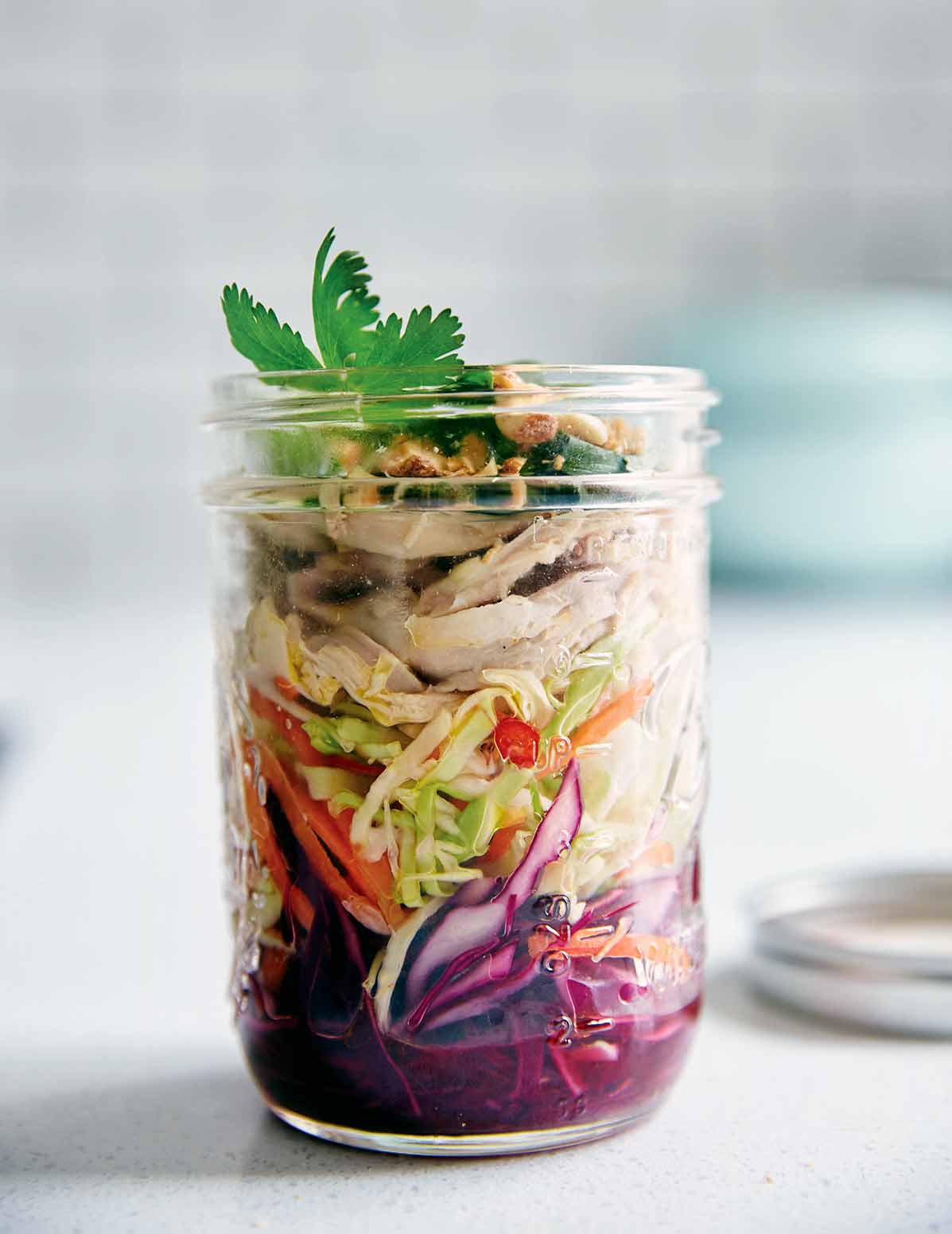 A glass jar filled with a layered Vietnamese chicken salad.