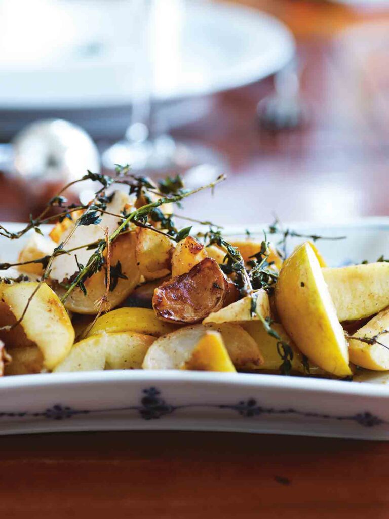A white platter filled with turnip and apples segments, topped with thyme sprigs.