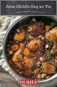 A metal pot filled with braised chicken, pearl onions, mushrooms, carrots, and thyme sprigs.