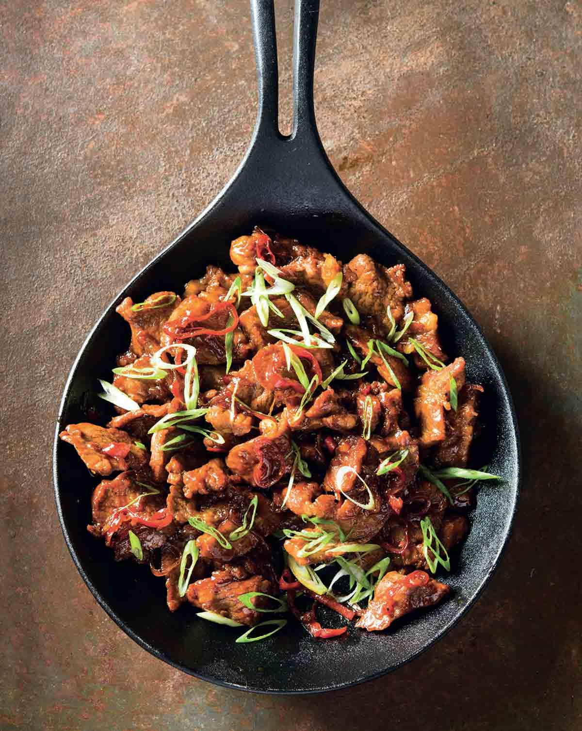 A spatula for stirring food picks off burnt food in a pan. Poor