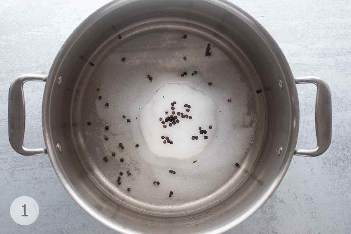 A stockpot with water, salt, sugar, and peppercorns.