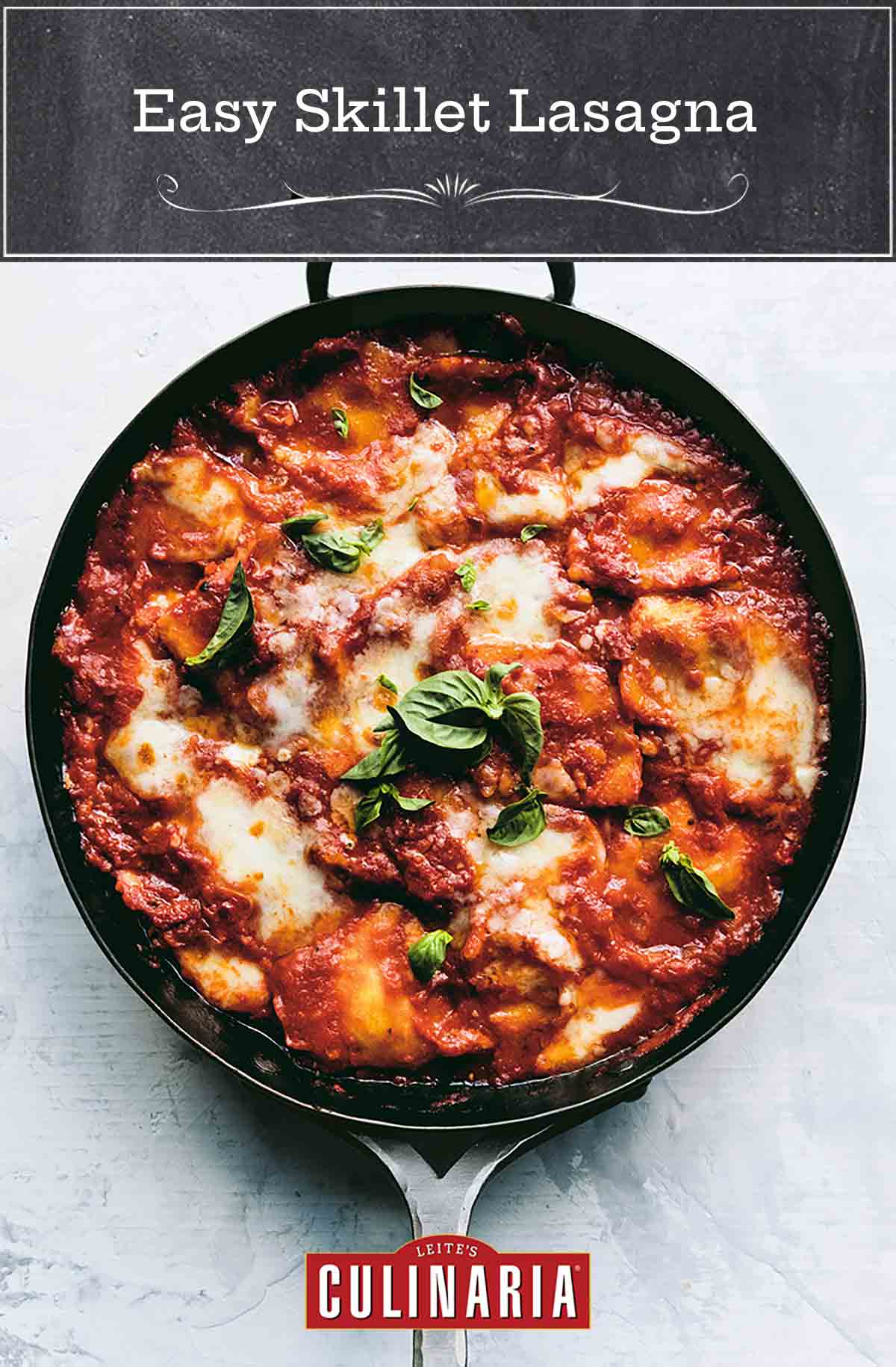 A metal skillet filled with easy skillet lasagna and garnished with basil leaves.