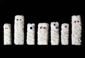 A line up of Halloween mummy Rice Krispies treats with googly candy eyes.