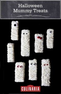 Nine Halloween mummy Rice Krispies treats with googly candy eyes on a black background.