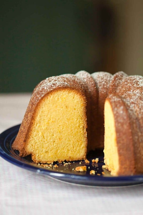 A partially cut Portuguese orange olive oil cake.