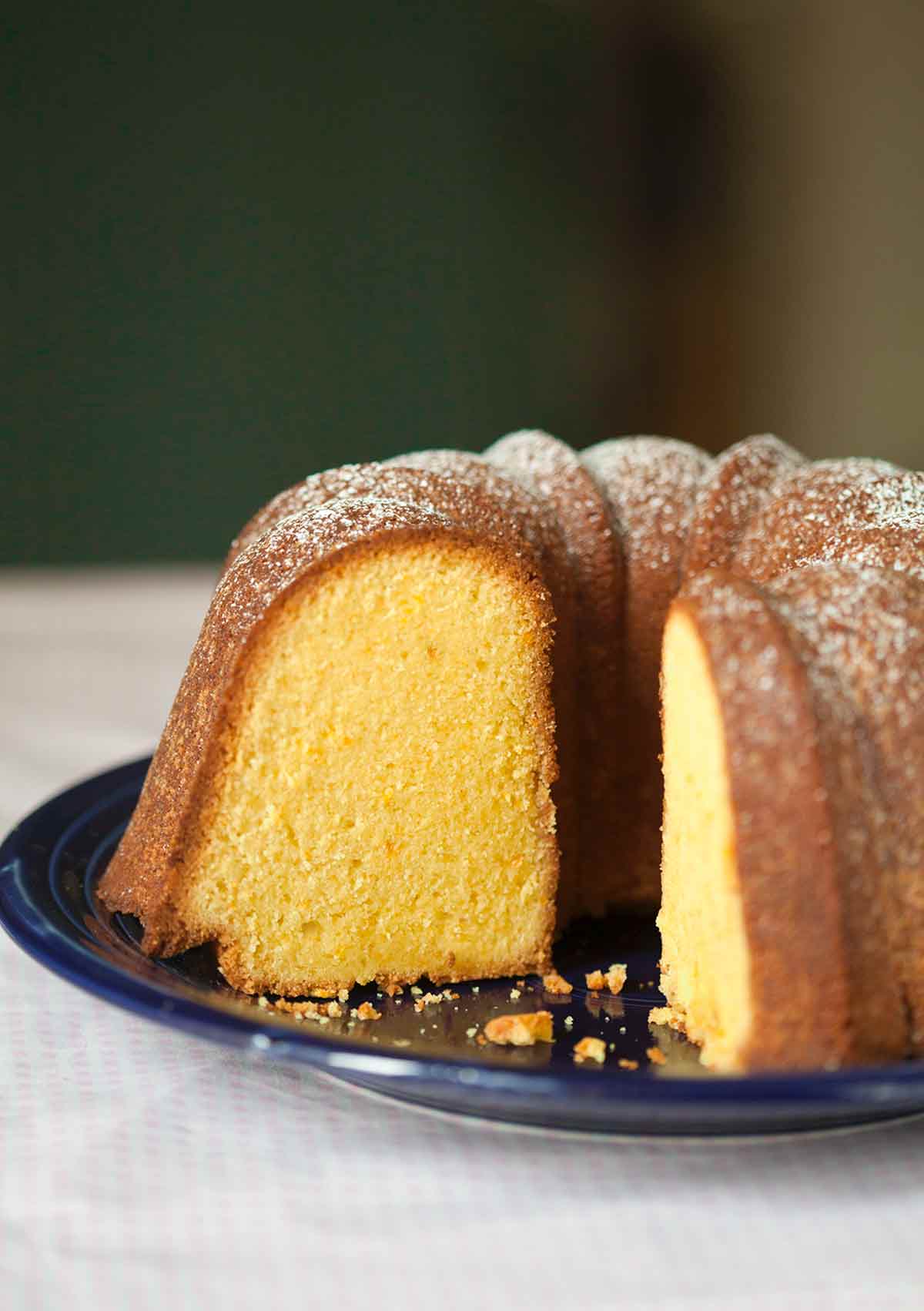 A partially cut Portuguese orange olive oil cake.