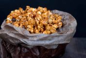 A waxed paper bag filled with caramel popcorn.