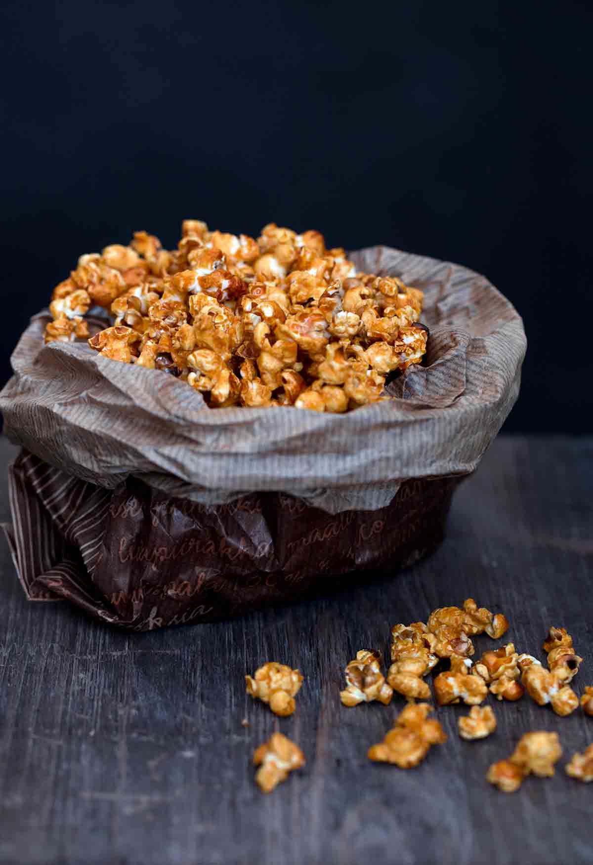 A waxed paper bag filled with caramel popcorn.