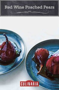 Two blue plates with red wine poached pears and a drizzle of sauce over them.