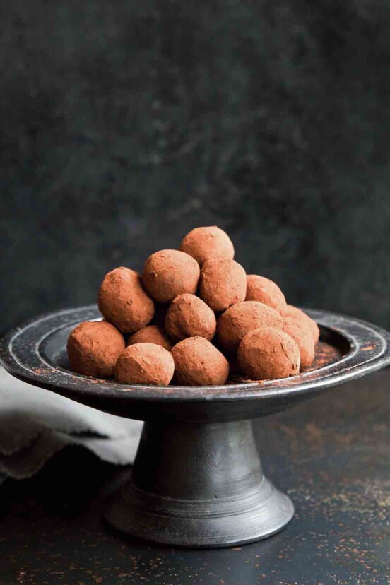 A pewter cake stand piled with chocolate truffles.