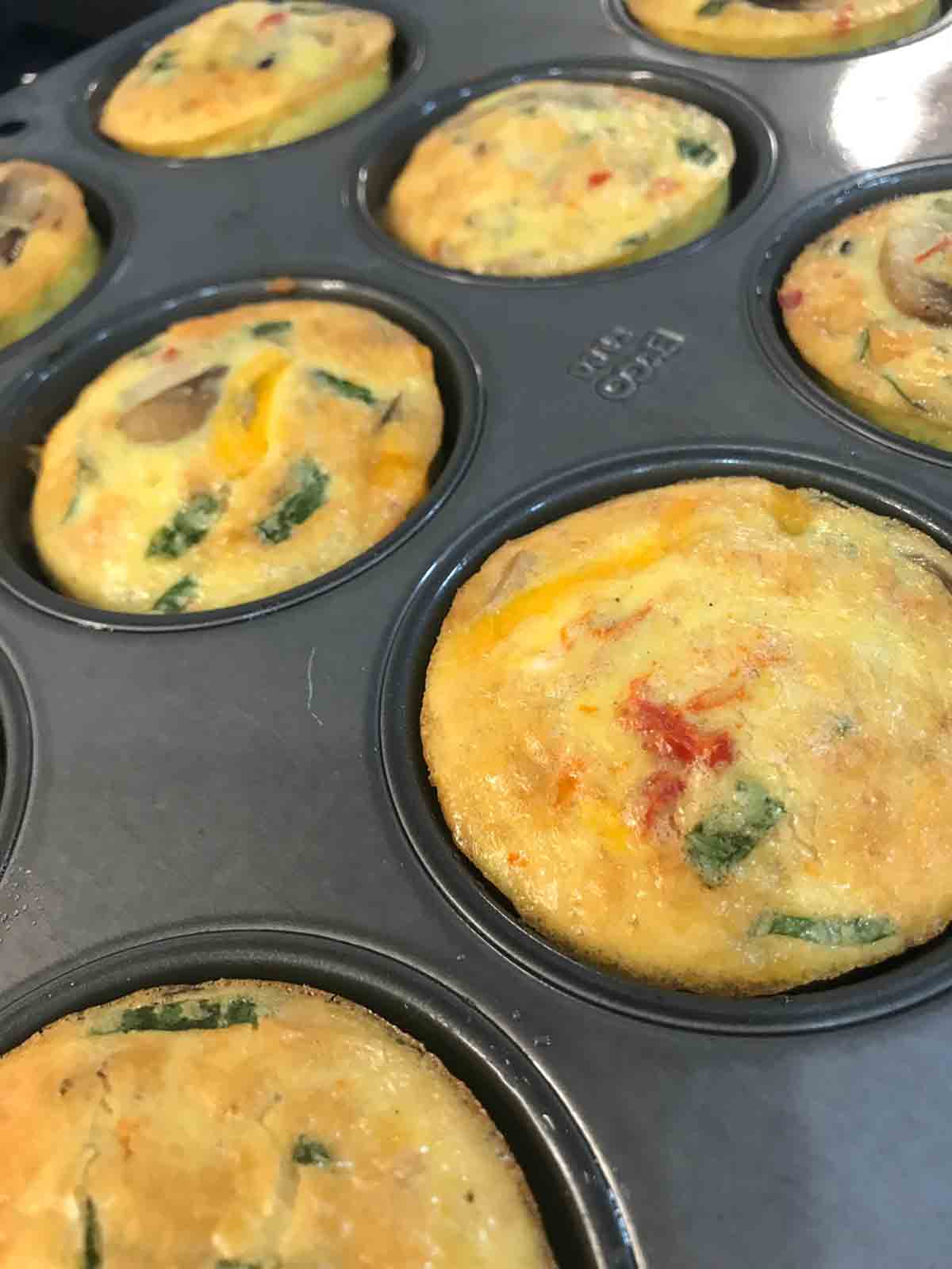 A muffin tin filled with baked egg bites.