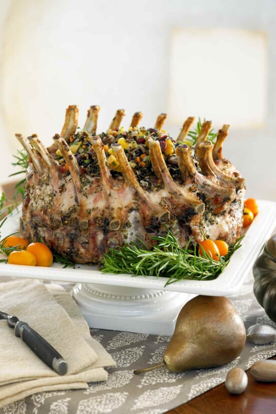 A garlic-herb pork crown roast on a square serving pedestal.