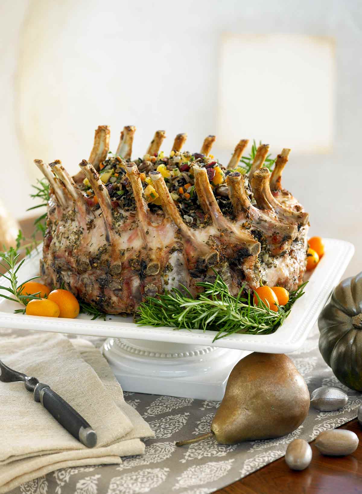 A garlic-herb pork crown roast on a square serving pedestal.