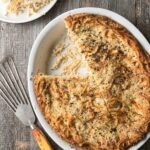Oval dish with noodle kugel, a cheese and pepper casserole with fettuccine and ricotta and Pecorino cheeses baked golden.
