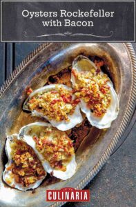 A tray of oysters Rockefeller with bacon--baked oysters topped with bread crumbs, bacon, and butter.