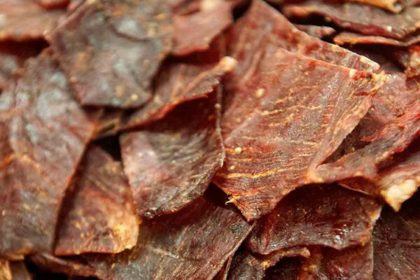 A pile of thin slices of homemade beef jerky.
