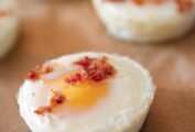 Four baked eggs sprinkled with chopped bacon.