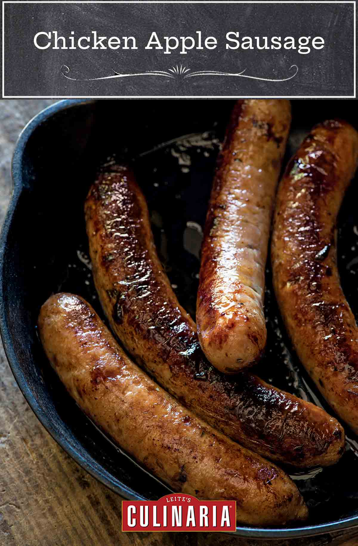 A cast-iron skillet with four cooked chicken apple sausages inside.