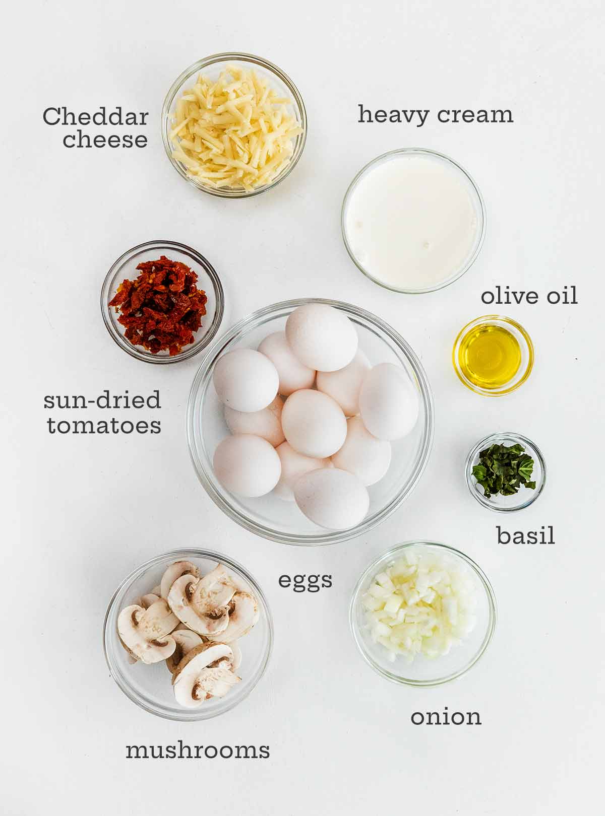Eggs, cheese, sun-dried tomatoes, oil, basil, onion, and mushrooms.