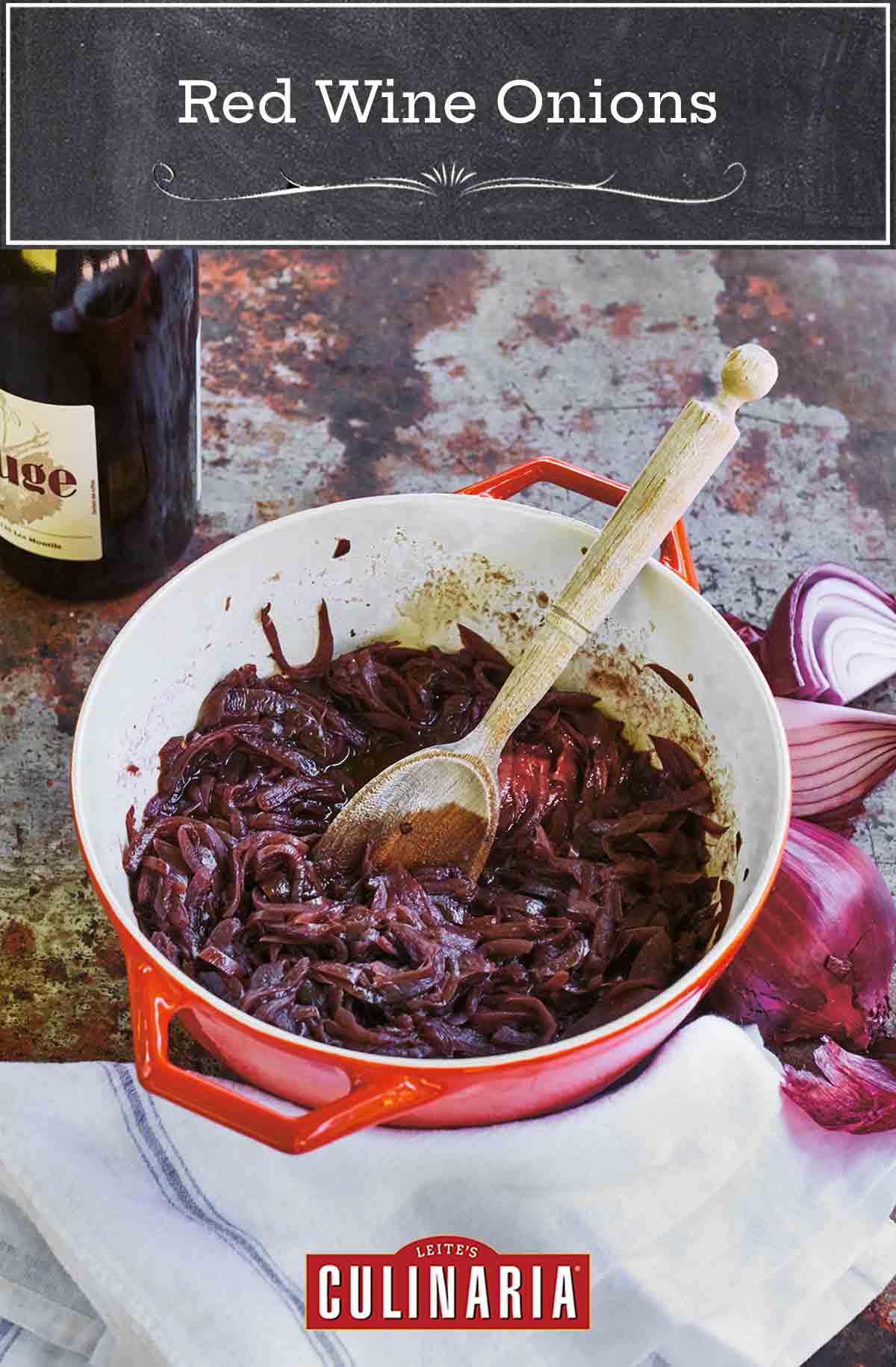 A red Le Creuset pot filled with red wine onions, that have been slowly cooked together.