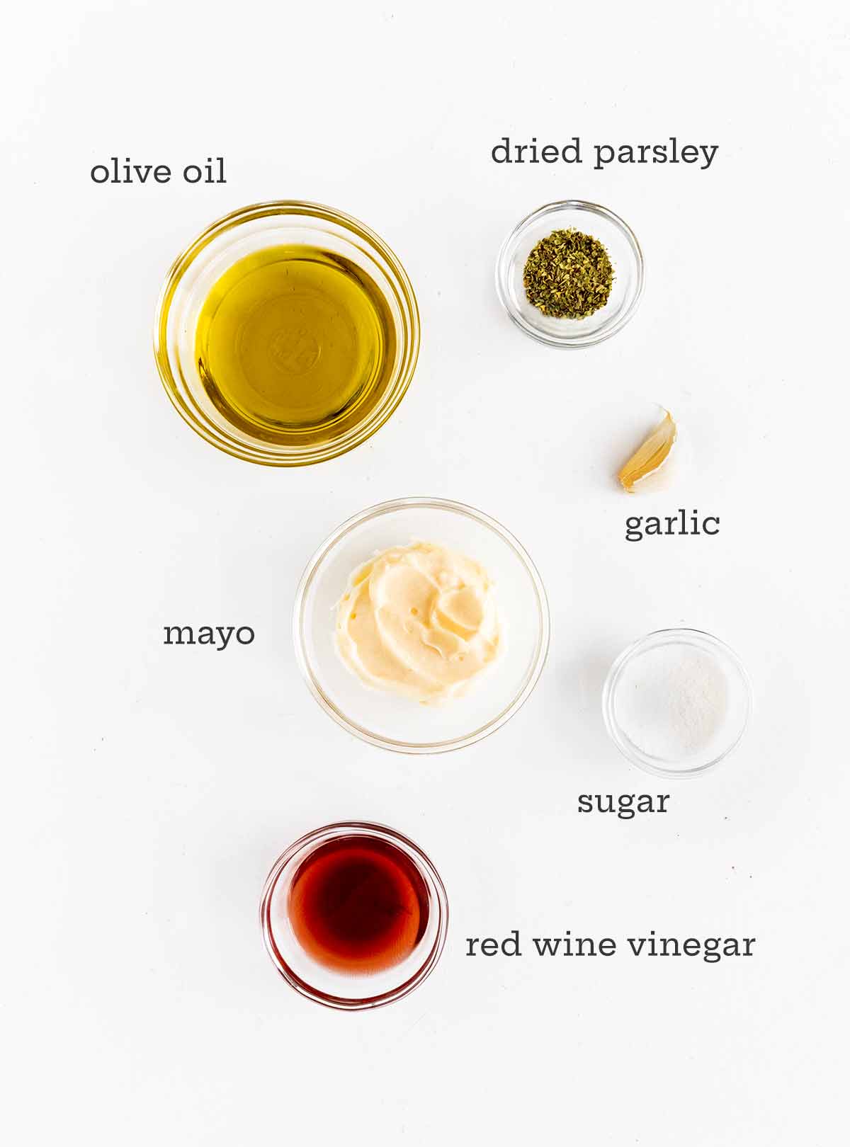 Ingredients for creamy Italian dressing -- olive oil, parsley, mayo, garlic, sugar, and red wine vinegar.