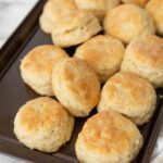 A baking sheet filled with cooked biscuits.