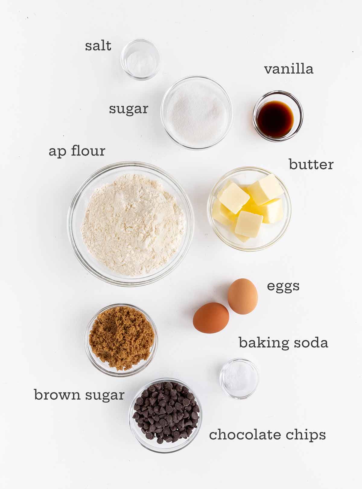 Ingredienser för mjuka chokladkakor - mjöl, smör, ägg, socker, vanilj, salt, bakpulver och chokladchips.