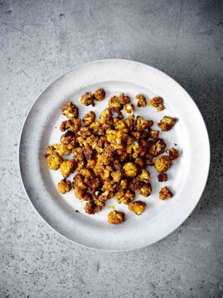 A plate filled with spicy roasted cauliflower florets.