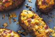 Four twice-baked potatoes with corned beef on a baking sheet.