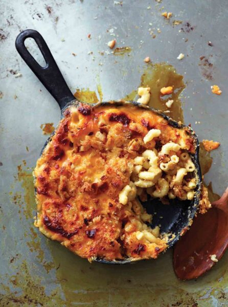 A cast iron skillet filled with baked macaroni and cheese.